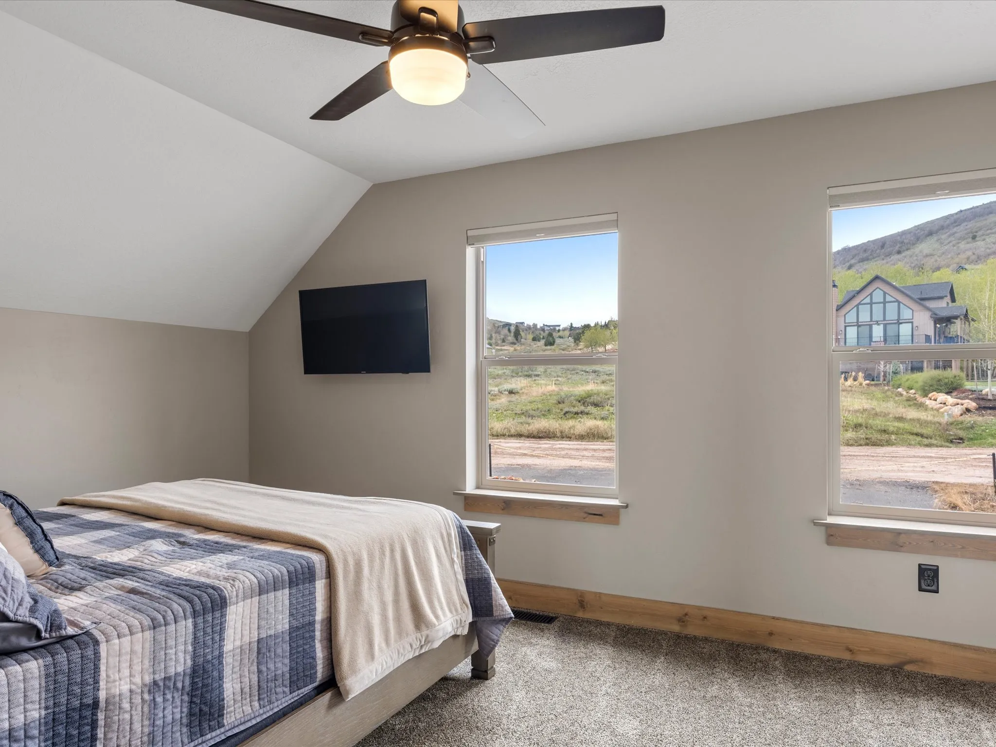 Bedroom featuring light carpet, lofted ceiling, and a ceiling fan