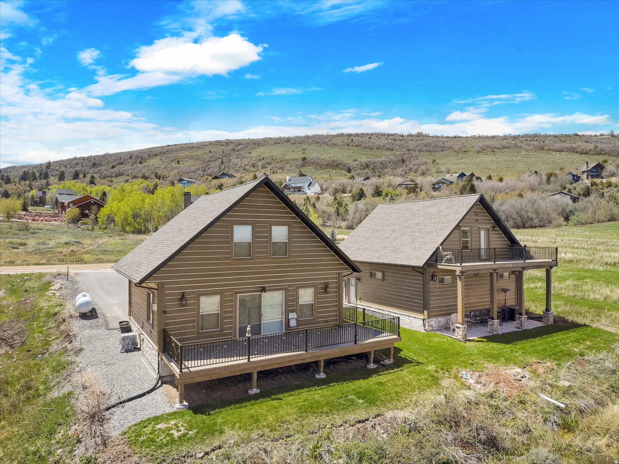 Two rustic-style homes with pitched roofs and wood-paneled siding