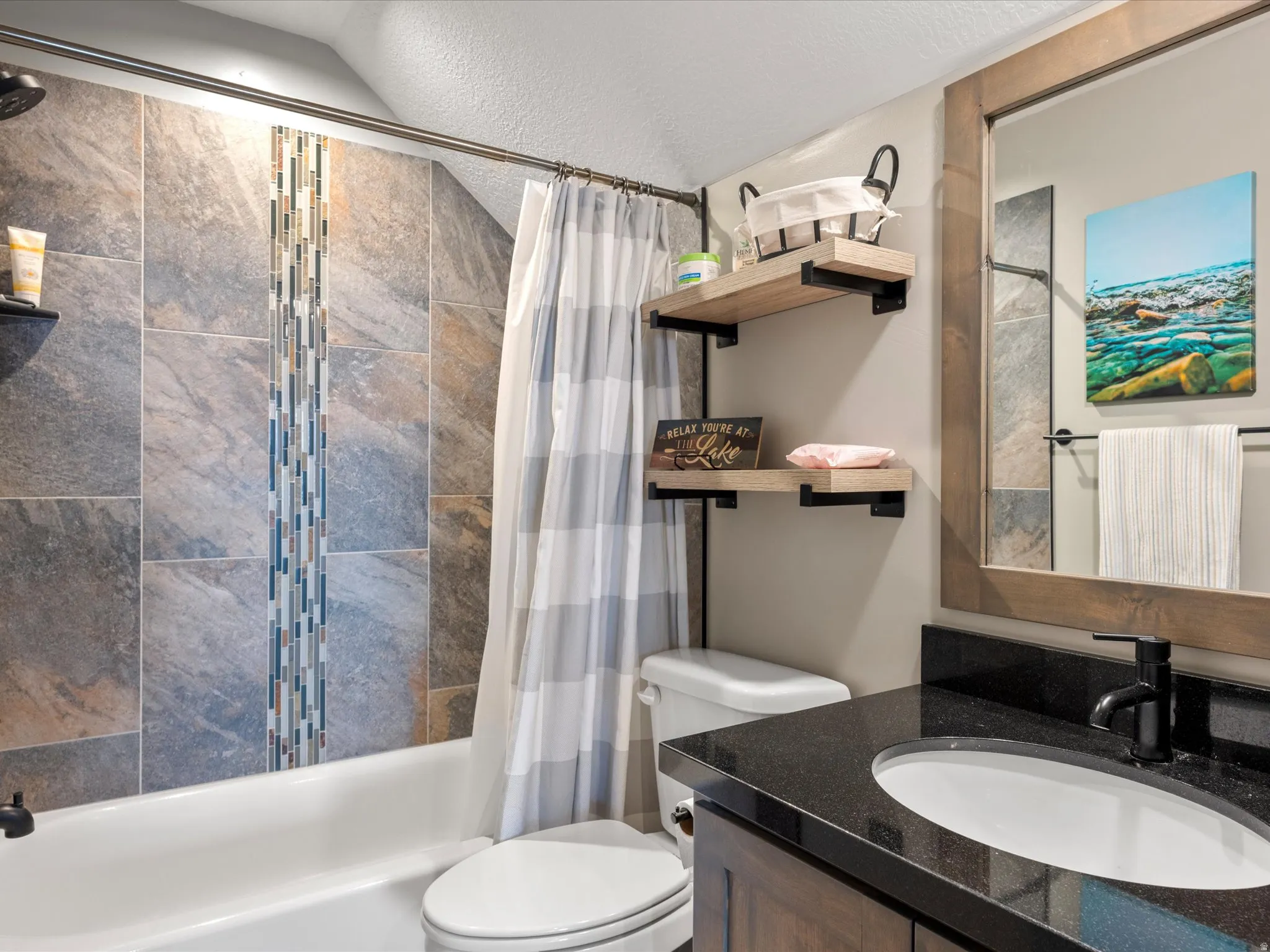 Full bath with vanity, shower / bathtub combination with curtain, and a textured ceiling