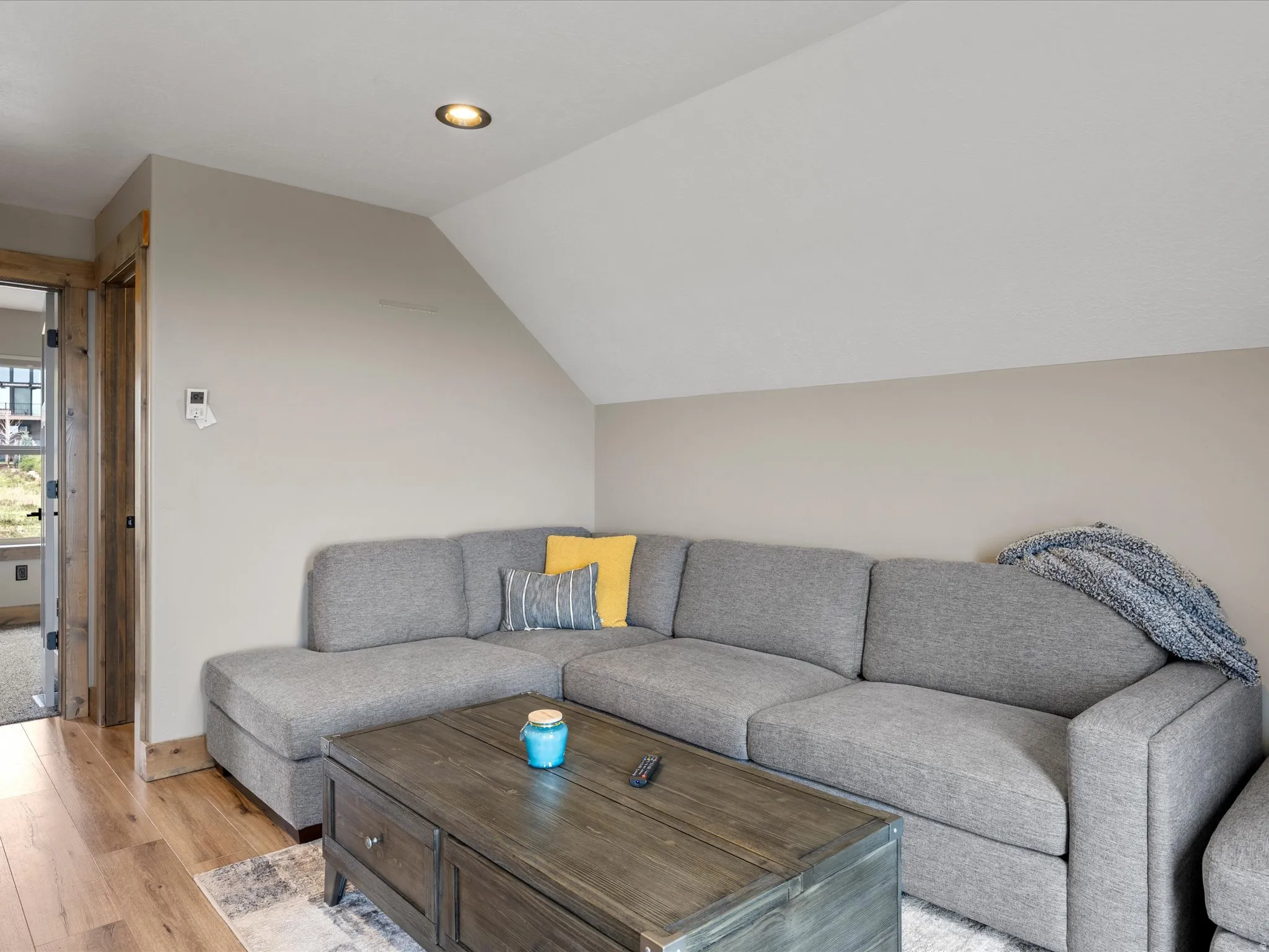 Living area featuring light wood finished floors and vaulted ceiling