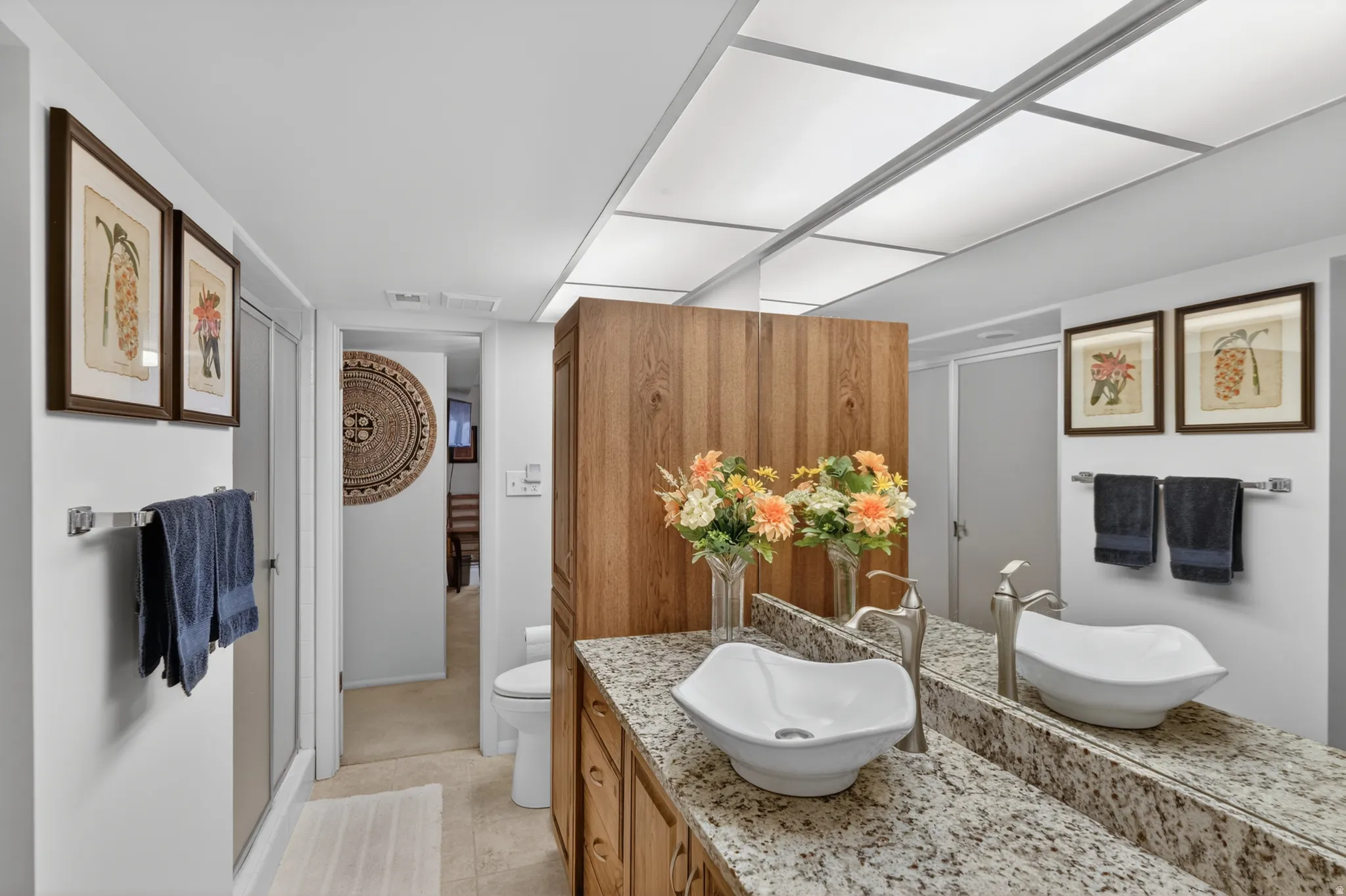 Full bathroom with a stall shower, vanity, and light tile patterned flooring