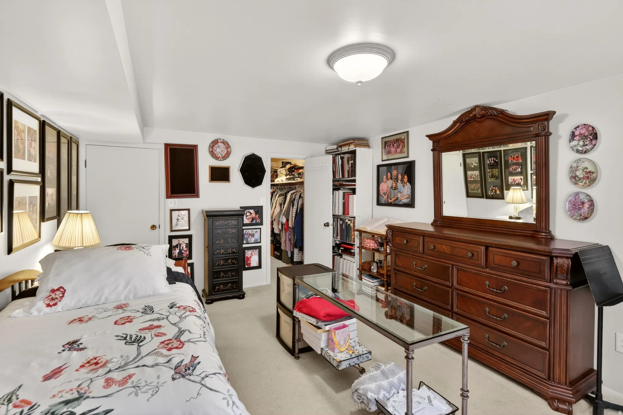 Bedroom with light colored carpet and a spacious closet