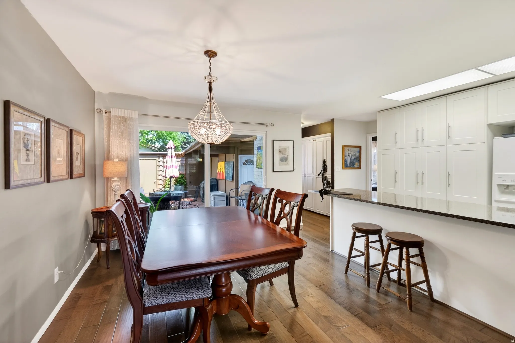 Dining space with dark wood-type flooring and baseboards