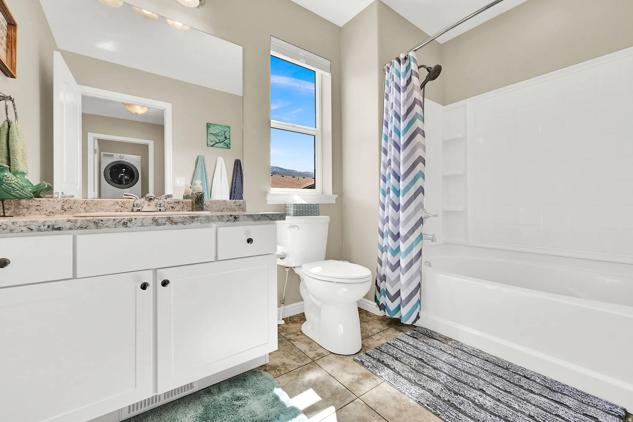 Full bath with vanity, shower / bath combo, and light tile patterned flooring