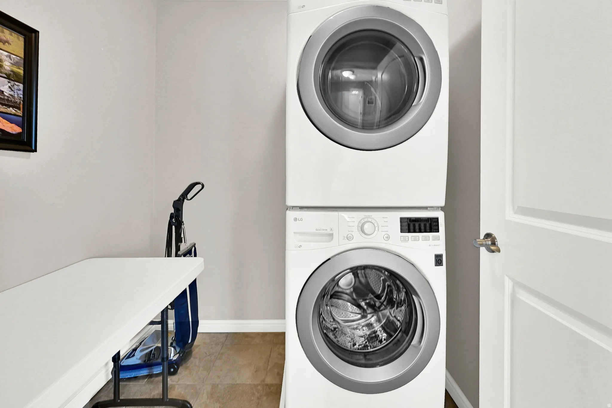 Laundry area with stacked washer / dryer and light tile patterned floors.  There is also a second location option for laundry on the 1st floor under the stairs.