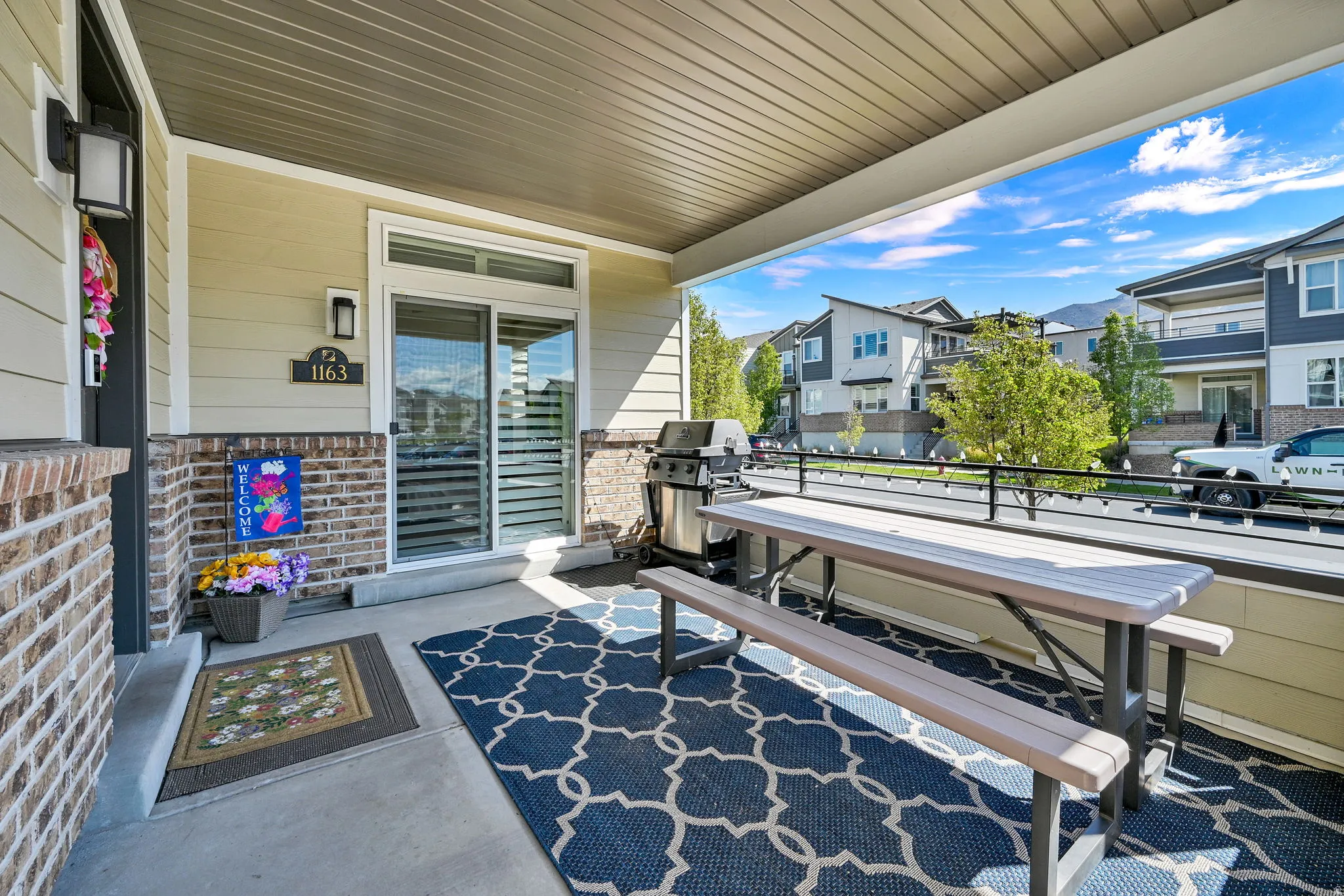 Front expansive entrance (on the left) porch/patio area showing the sliding door from the primary suite