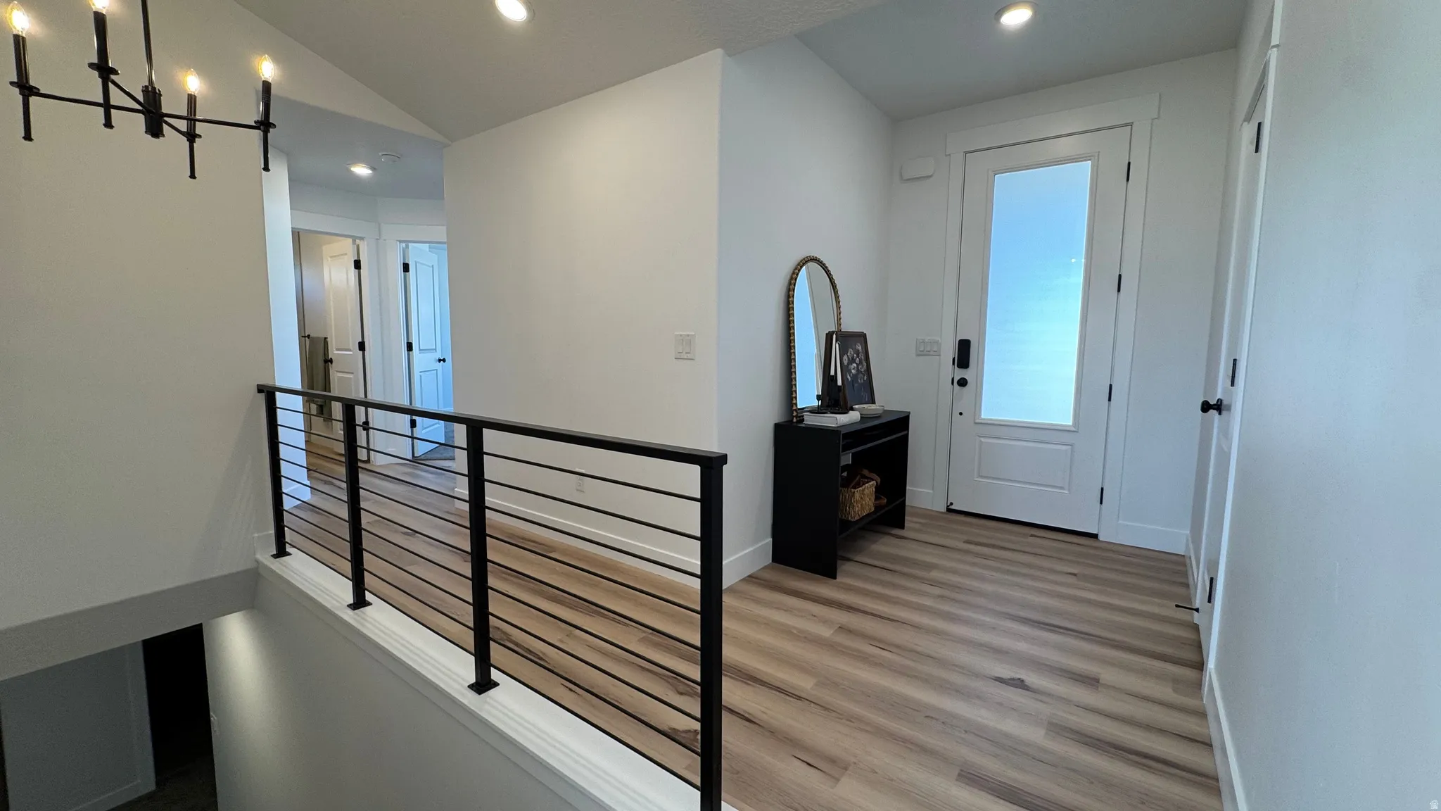 Entryway featuring wood-finish flooring, a white paneled door with frosted glass insert, and recessed lighting