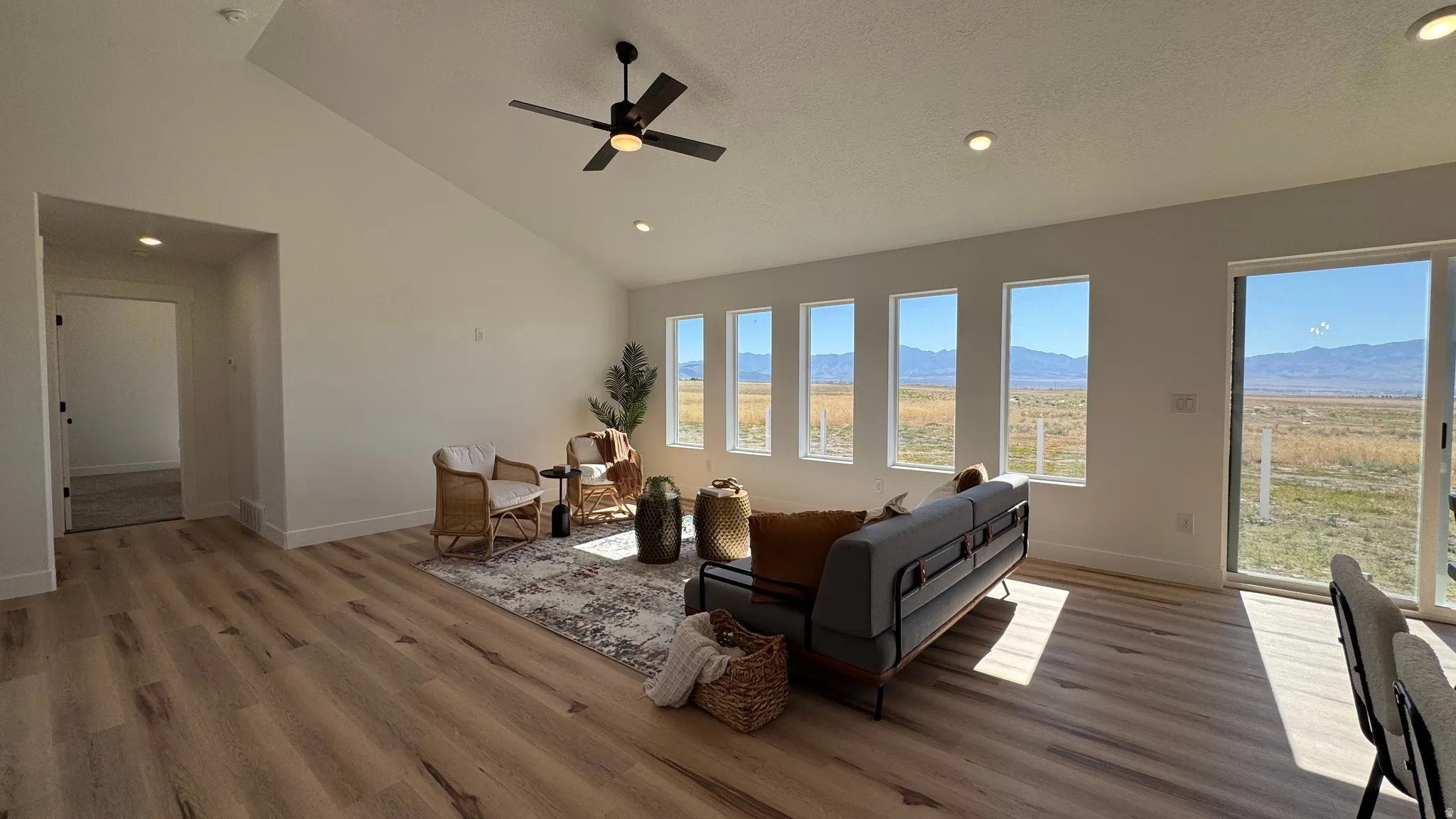 Open concept living area featuring wood-finish flooring, a vaulted ceiling, and recessed lighting