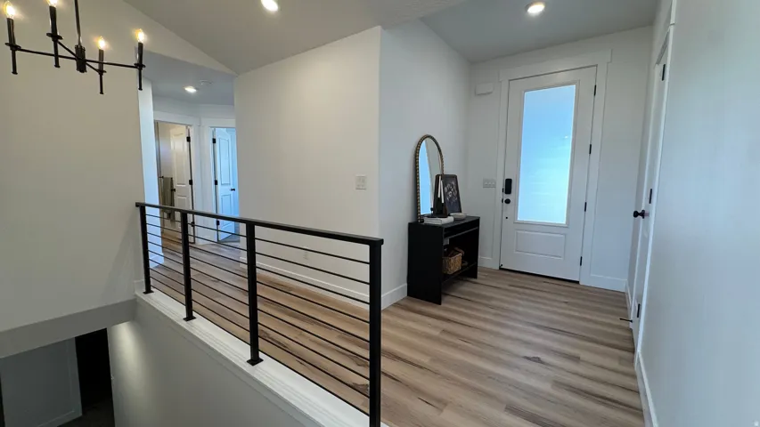Entryway featuring wood-finish flooring, a white paneled door with frosted glass insert, and recessed lighting