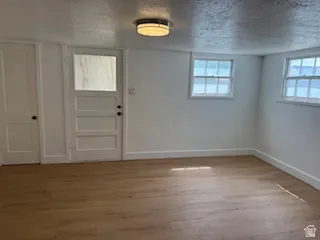 Foyer with light wood-style floors and a textured ceiling