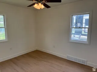Empty room featuring light wood finished floors and a ceiling fan