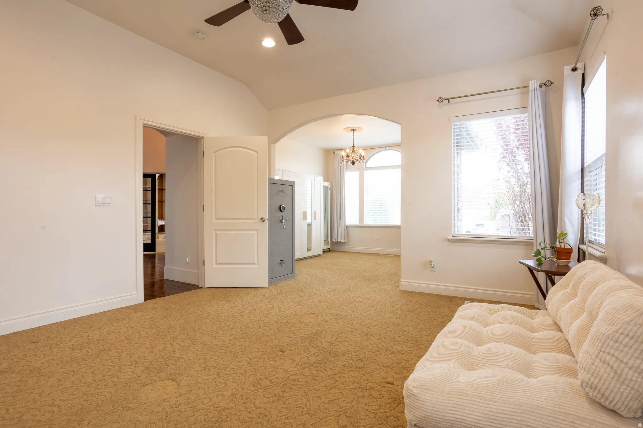 Sitting room with arched walkways, lofted ceiling, suspended lighting, a ceiling fan, and carpet floors