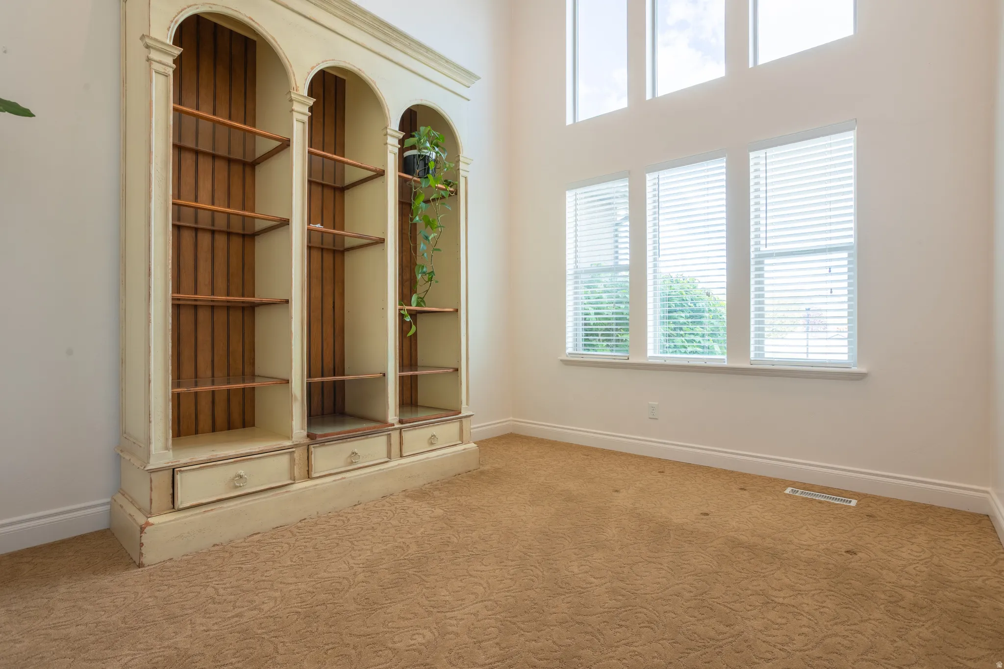Interior space with light carpet and a high ceiling