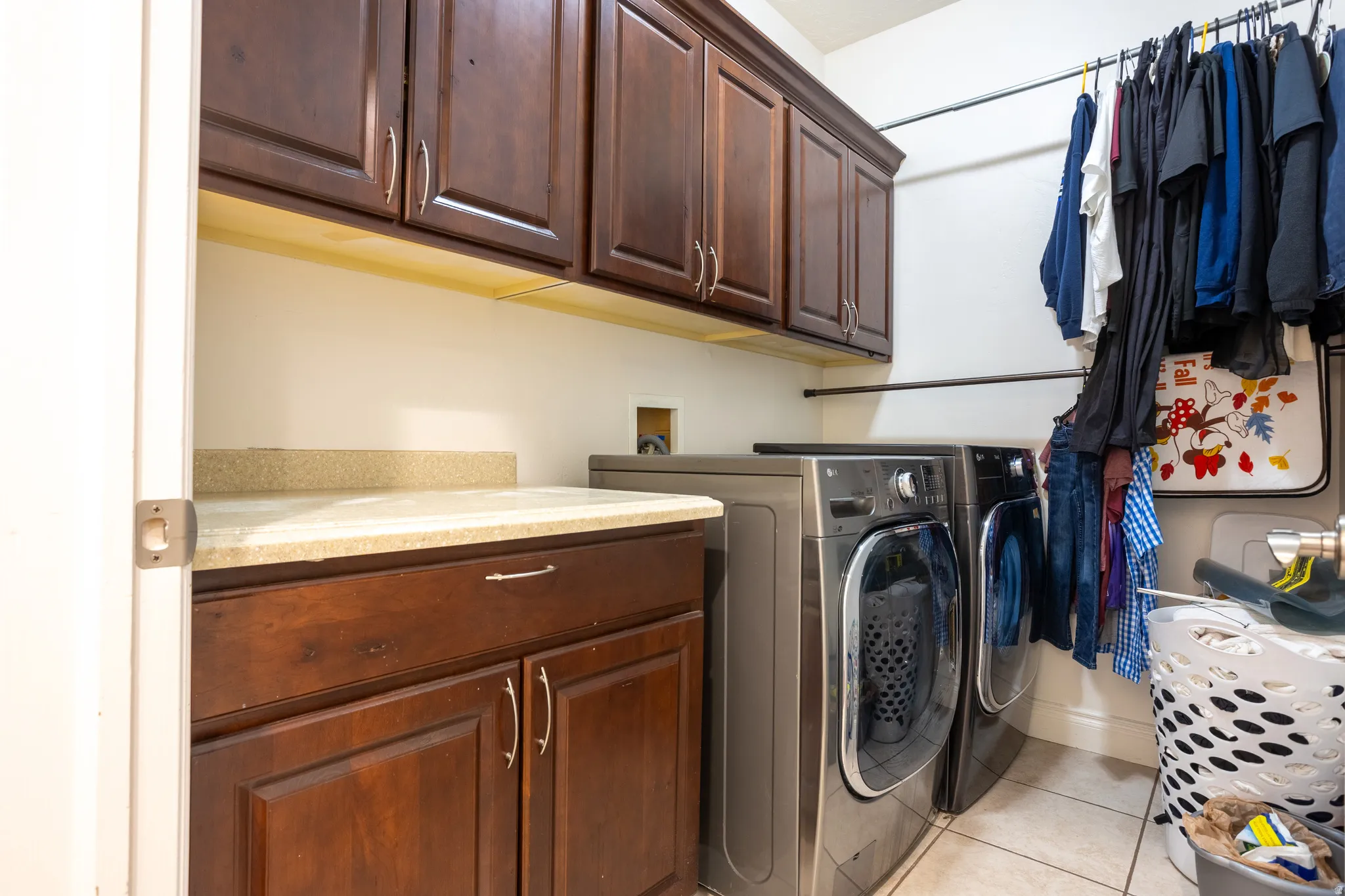 Laundry area featuring cabinet space, washer and dryer, and light tile patterned floors