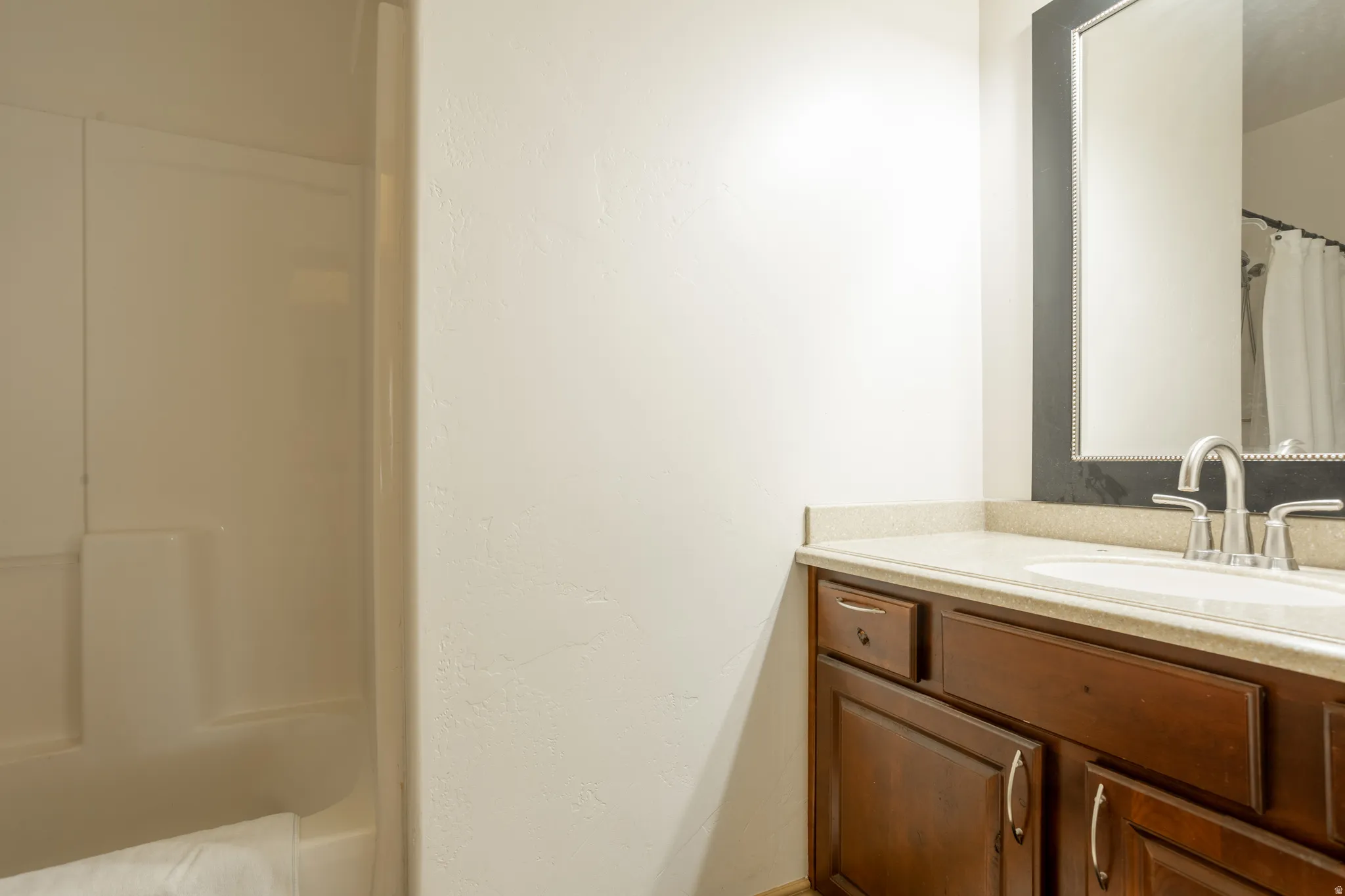 Bathroom with a shower with curtain and vanity