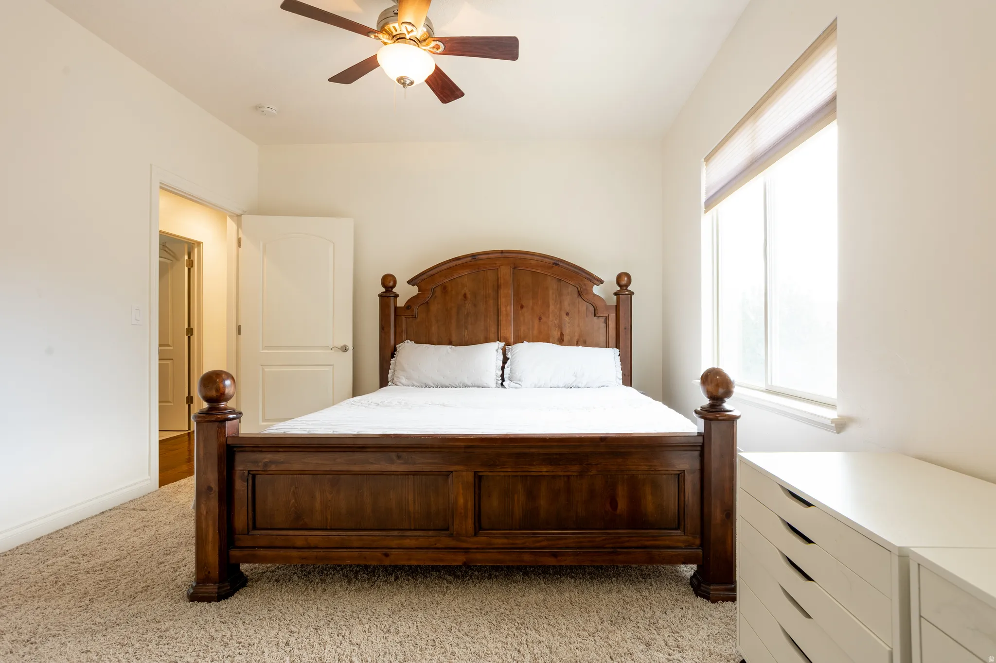 Bedroom with light carpet and a ceiling fan