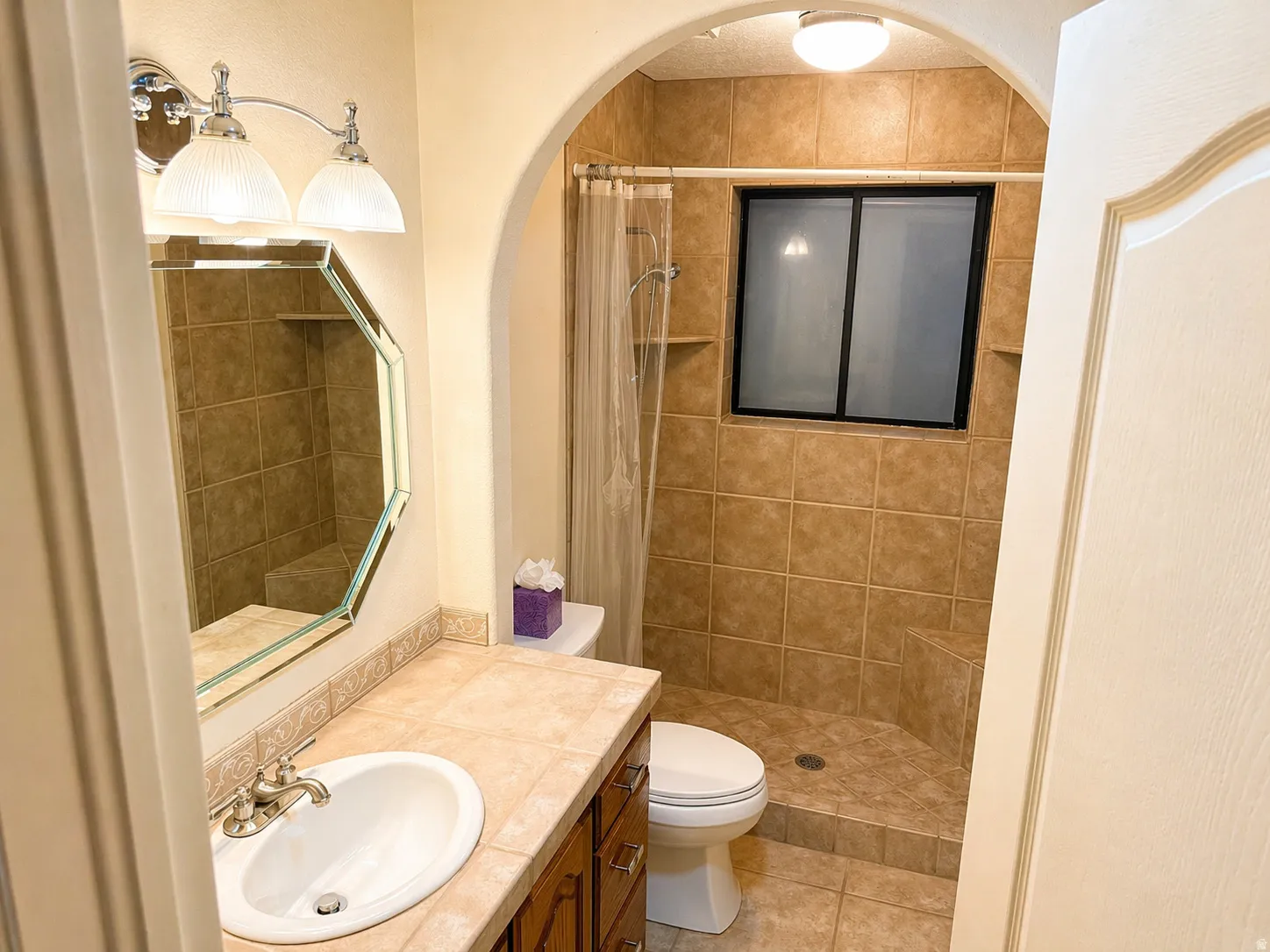 Full bath with vanity, a shower stall, and light tile patterned flooring