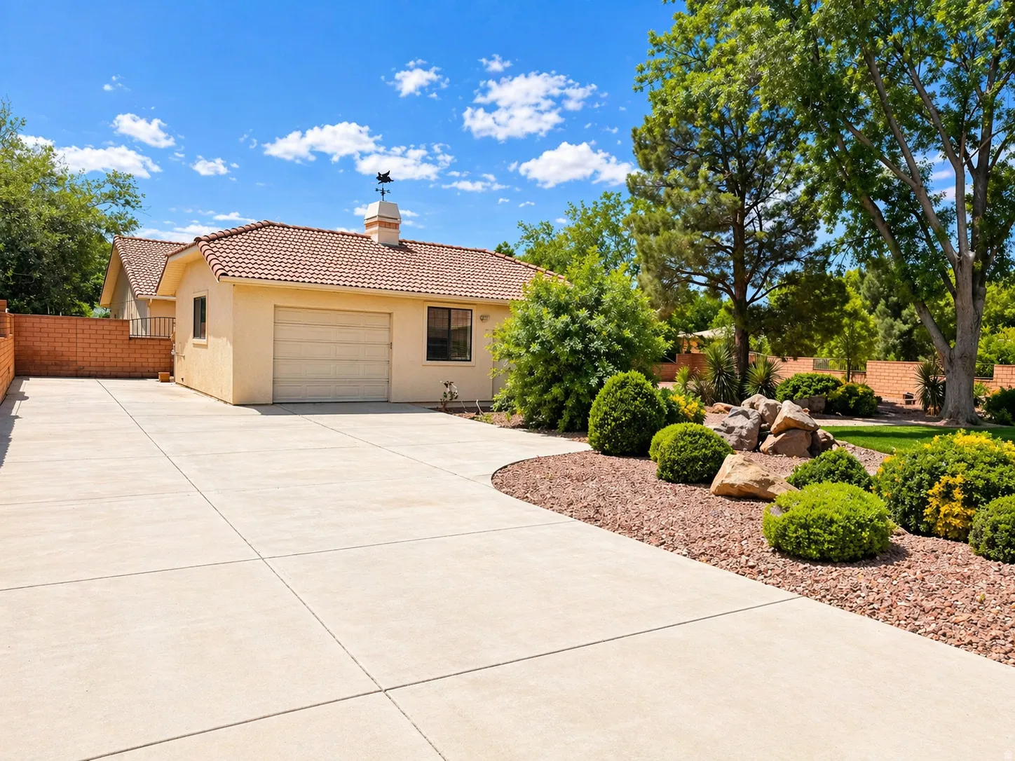 View of front of house featuring concrete driveway, a chimney, a tile roof, stucco siding, and a garage