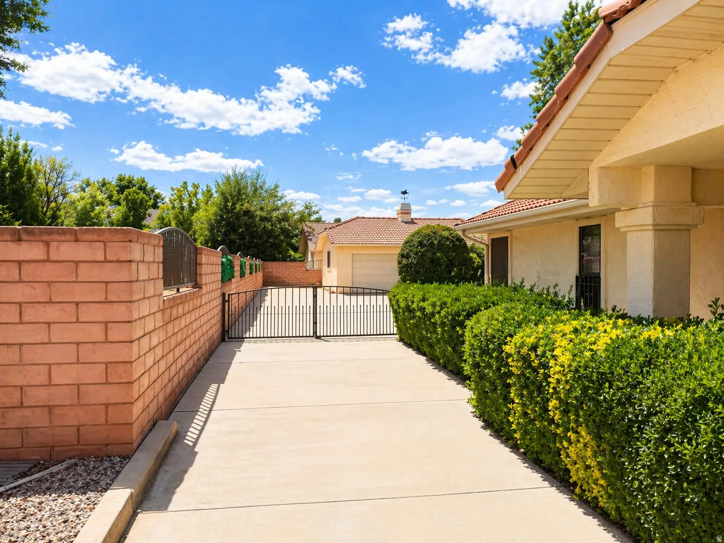 View of patio featuring a gate, a garage, and concrete driveway
