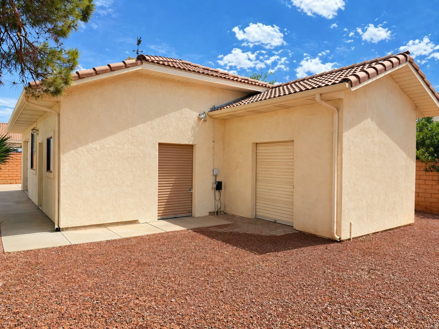 Back of house with stucco siding and a tiled roof