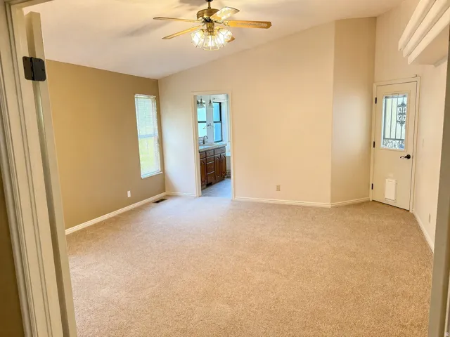 Unfurnished room with light carpet, ceiling fan, and lofted ceiling