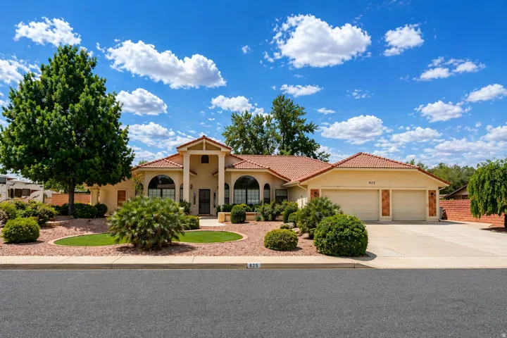 Mediterranean / spanish-style house with an attached garage, a tile roof, driveway, and stucco siding