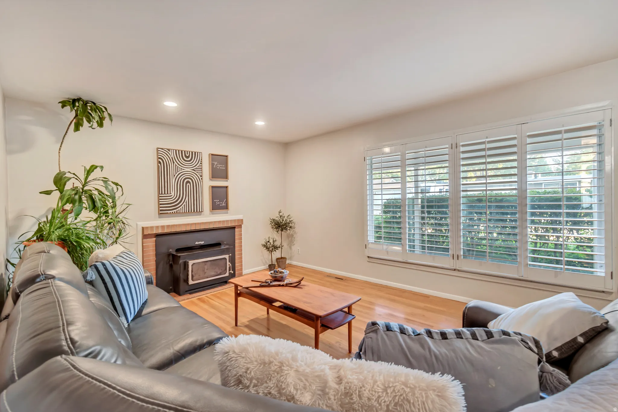 Family room featuring original hardwood floors, recessed lighting and a cozy fireplace.