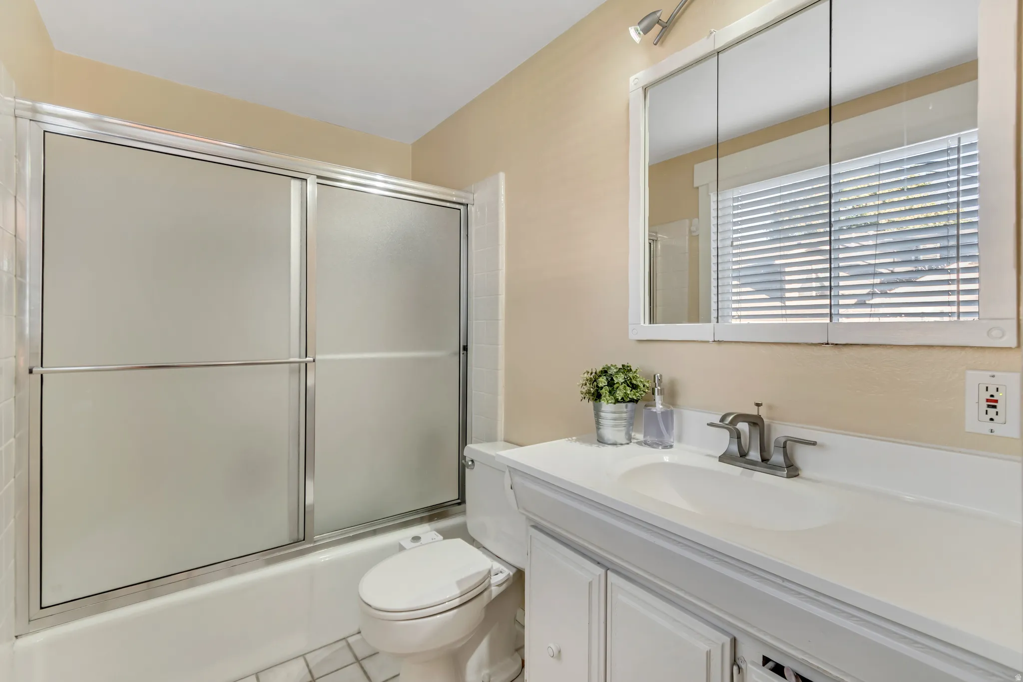 Full master bath featuring vanity, shower /bath combination with glass door.