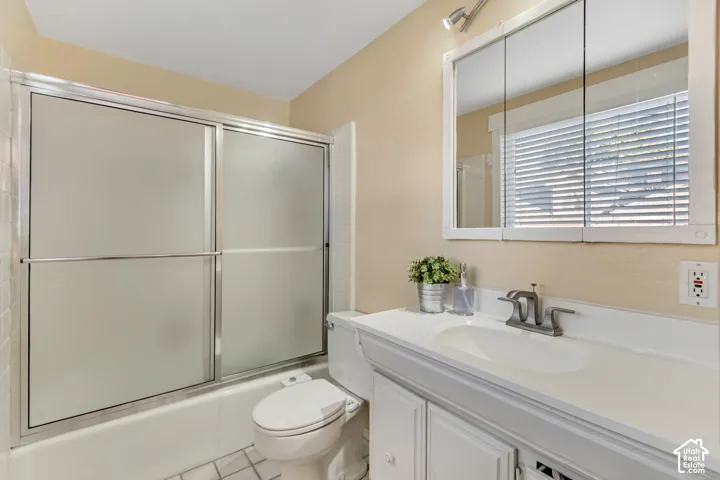 Full master bath featuring vanity, shower /bath combination with glass door.