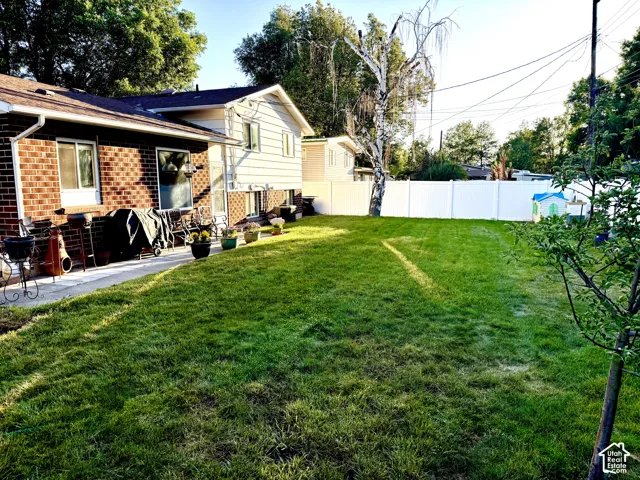 Expansive green lawn with a white privacy fence