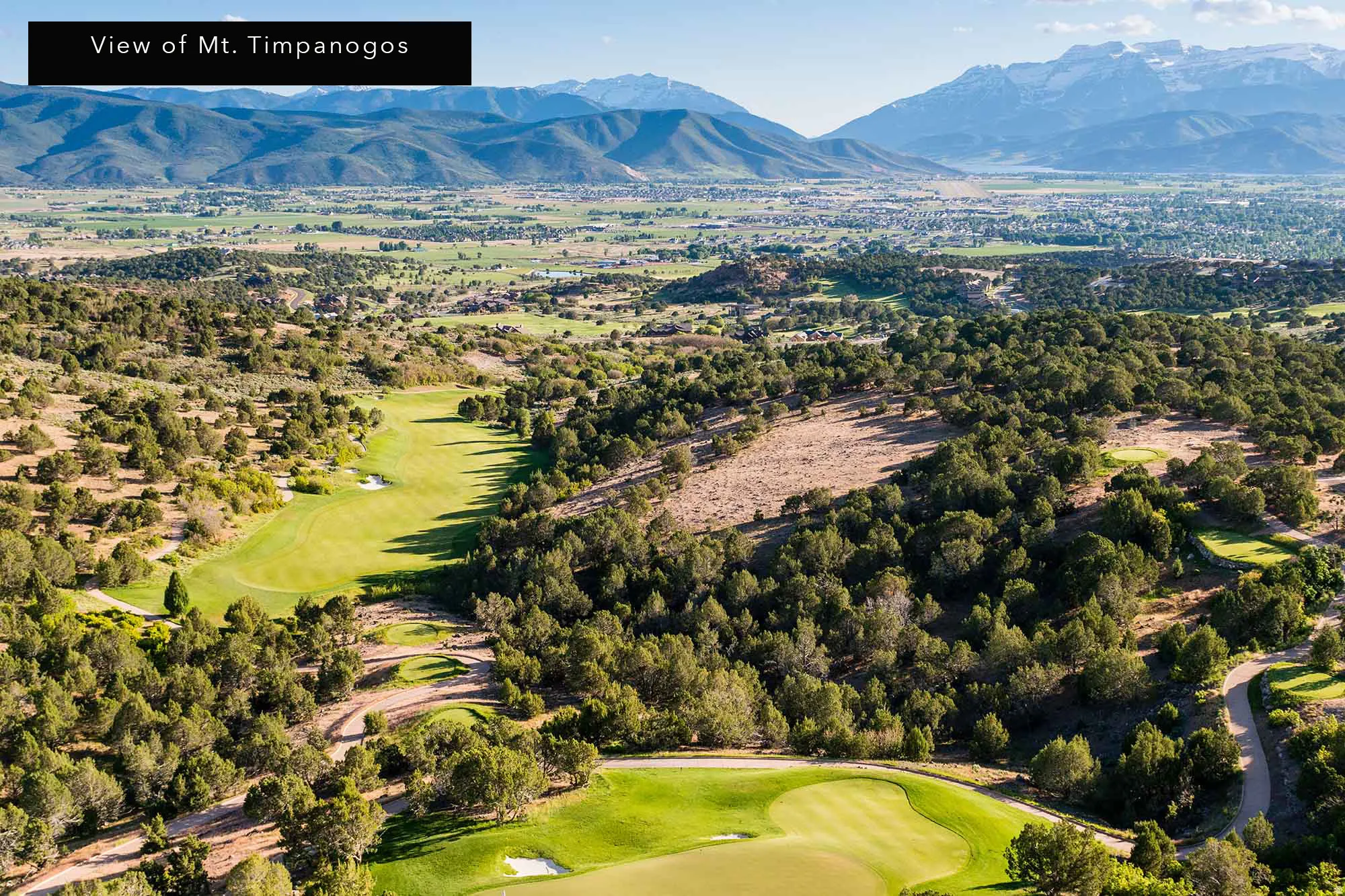 Aerial view of a golf course and mountains