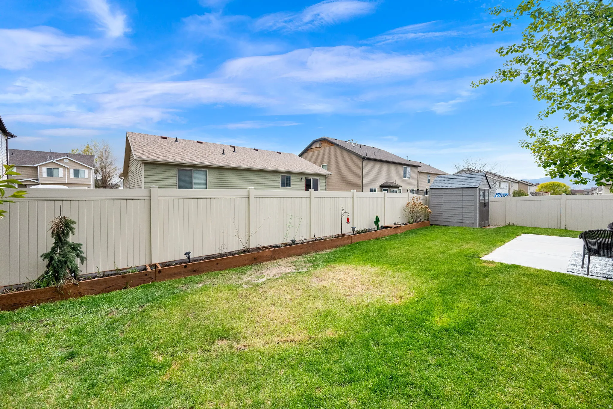 Fenced backyard with a storage shed and a residential view