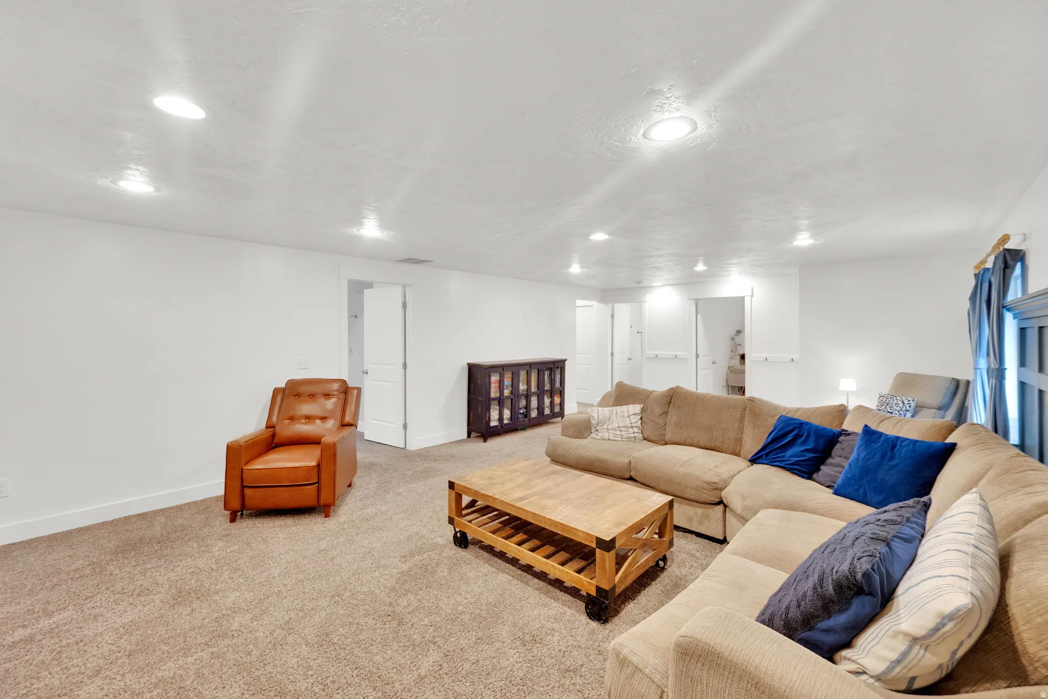 Carpeted living room featuring baseboards and recessed lighting