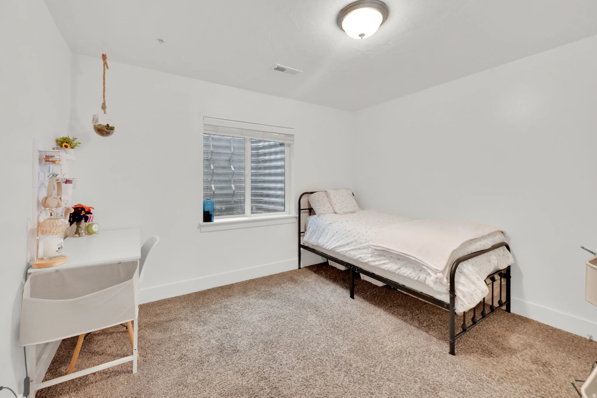 Bedroom featuring light colored carpet and baseboards