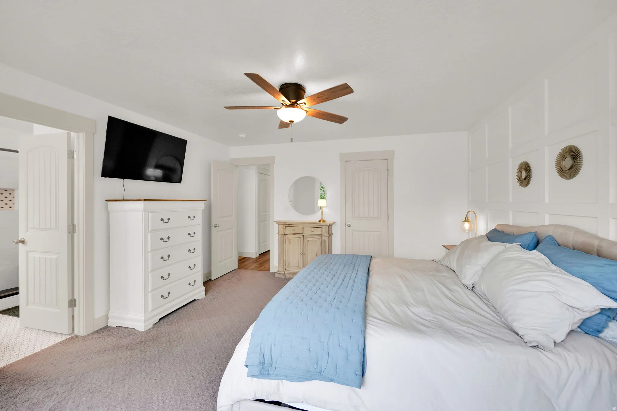 Bedroom featuring connected bathroom, light carpet, a closet, and a ceiling fan