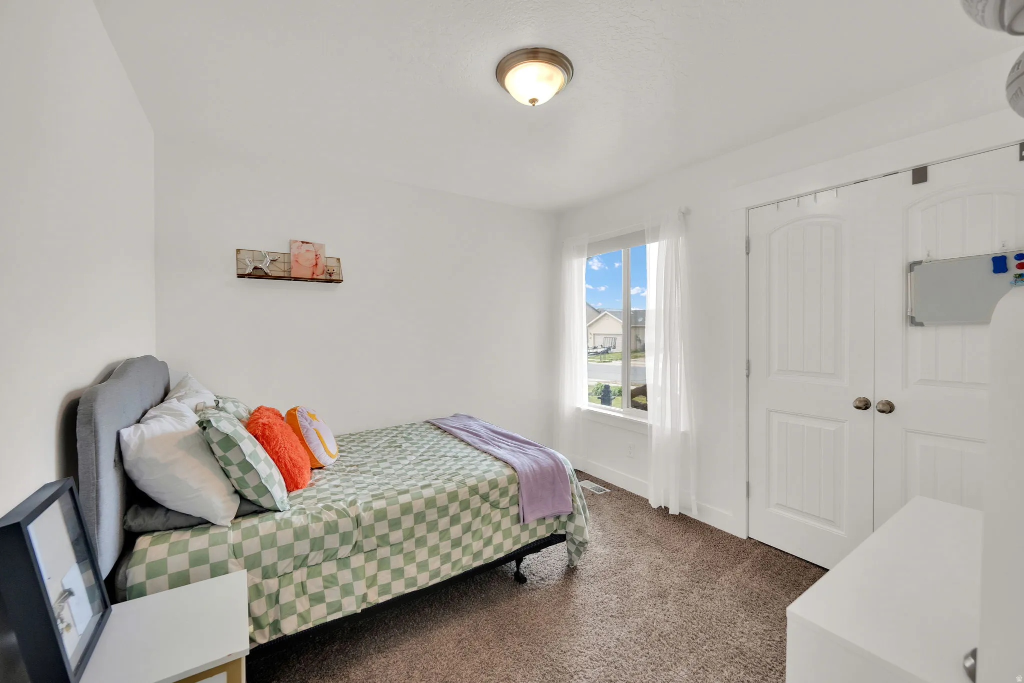 Bedroom with a closet and dark colored carpet