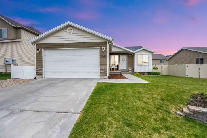 Ranch-style house featuring concrete driveway and an attached garage