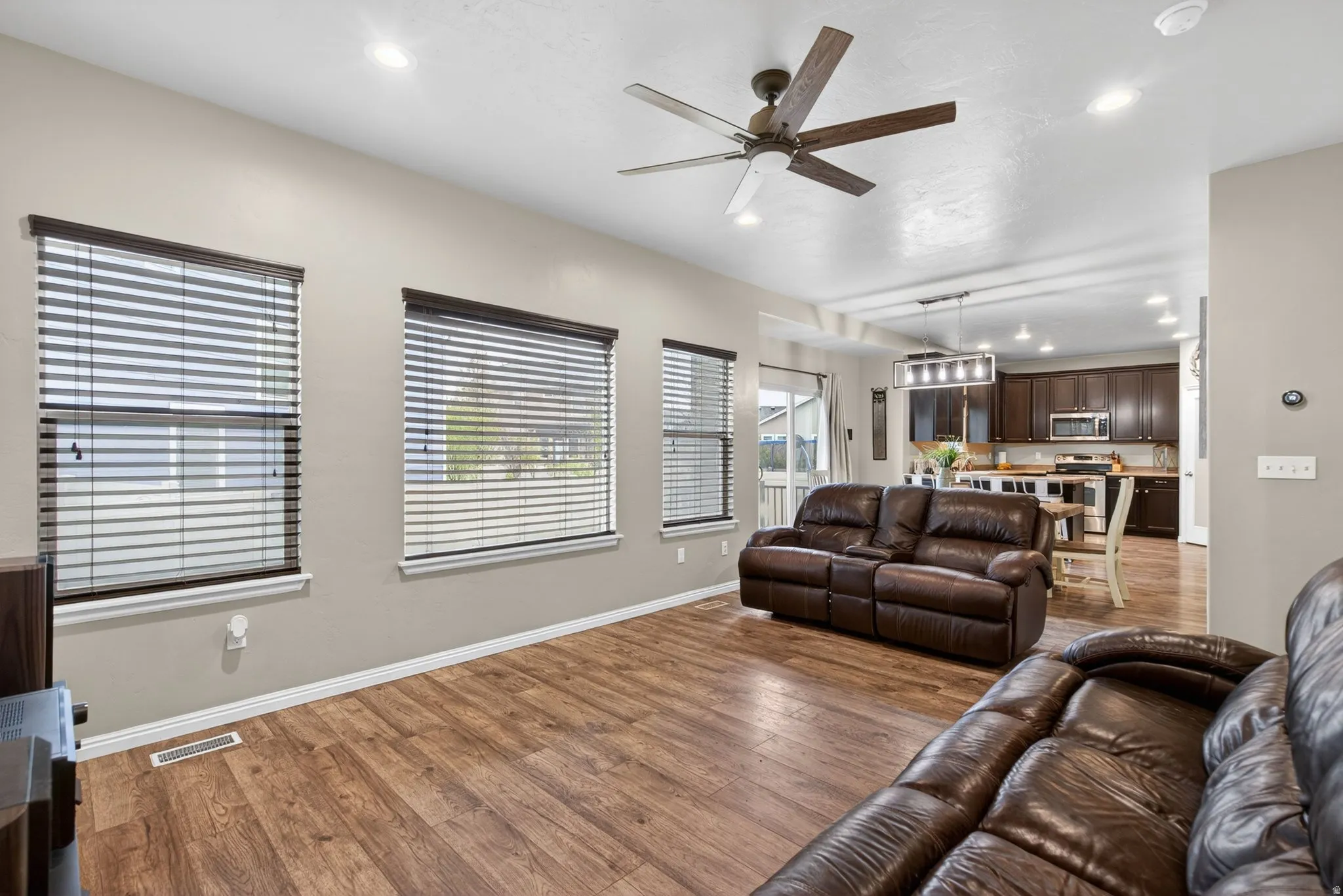 Living room featuring recessed lighting, ceiling fan, and wood-type flooring