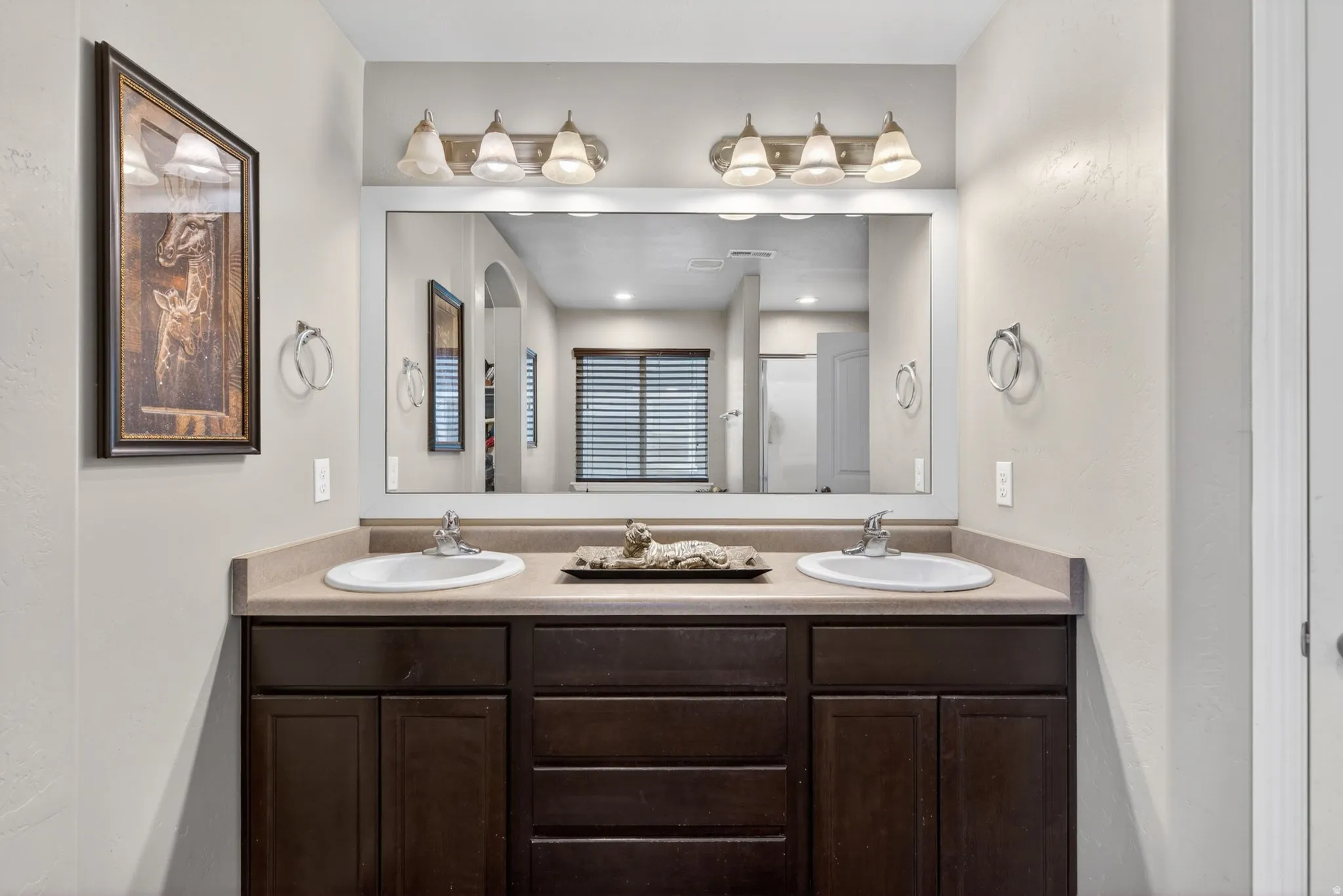 Bathroom featuring double vanity and a stall shower