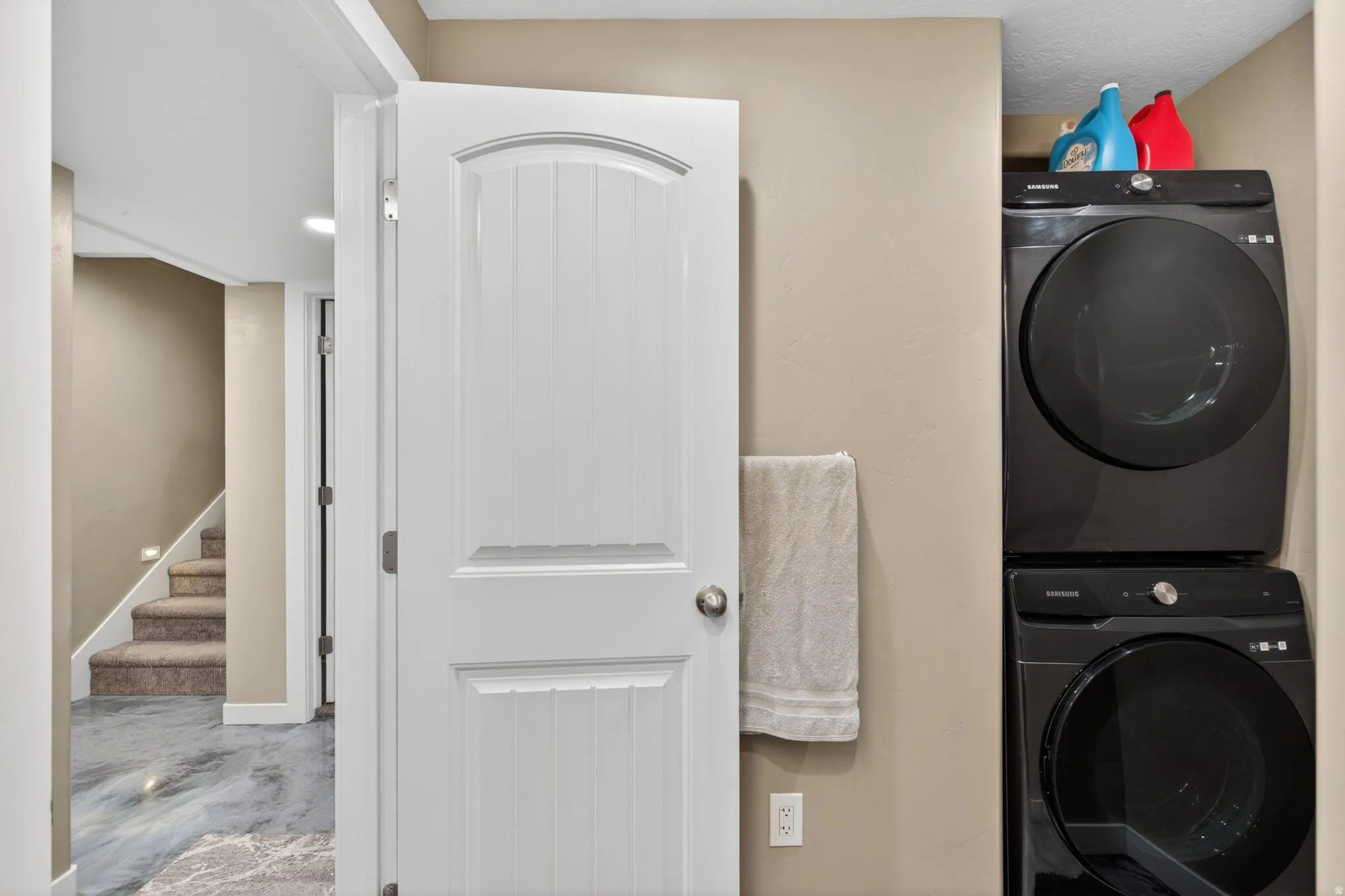 Laundry area featuring stacked washer / drying machine and baseboards