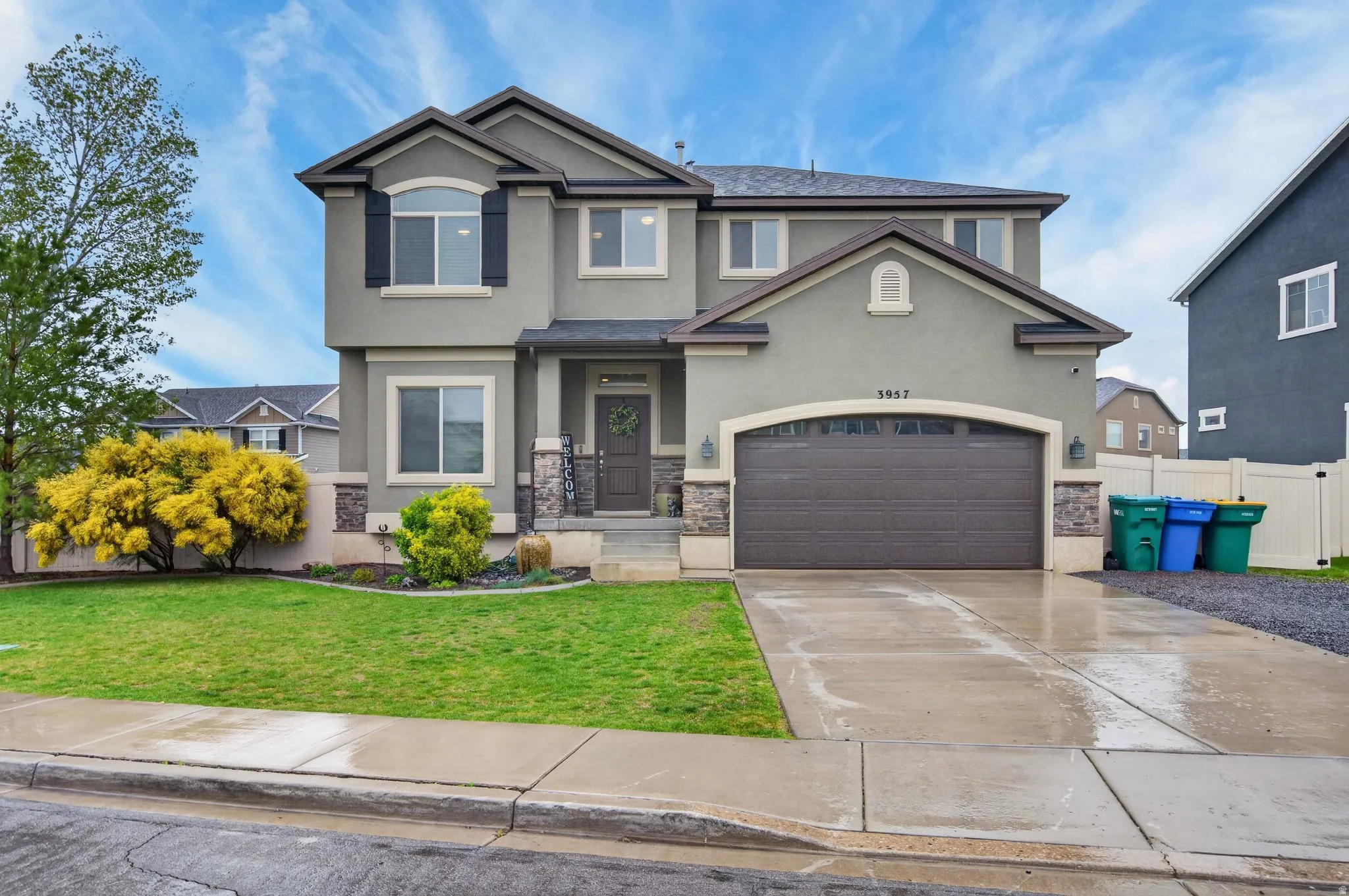 View of front facade with stucco siding, concrete driveway, a garage, and stone siding