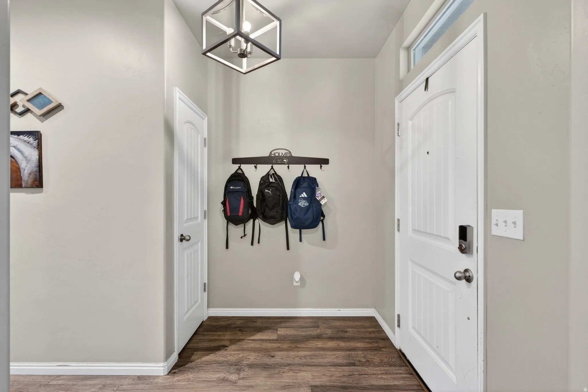 Doorway to outside with a chandelier and wood finished floors
