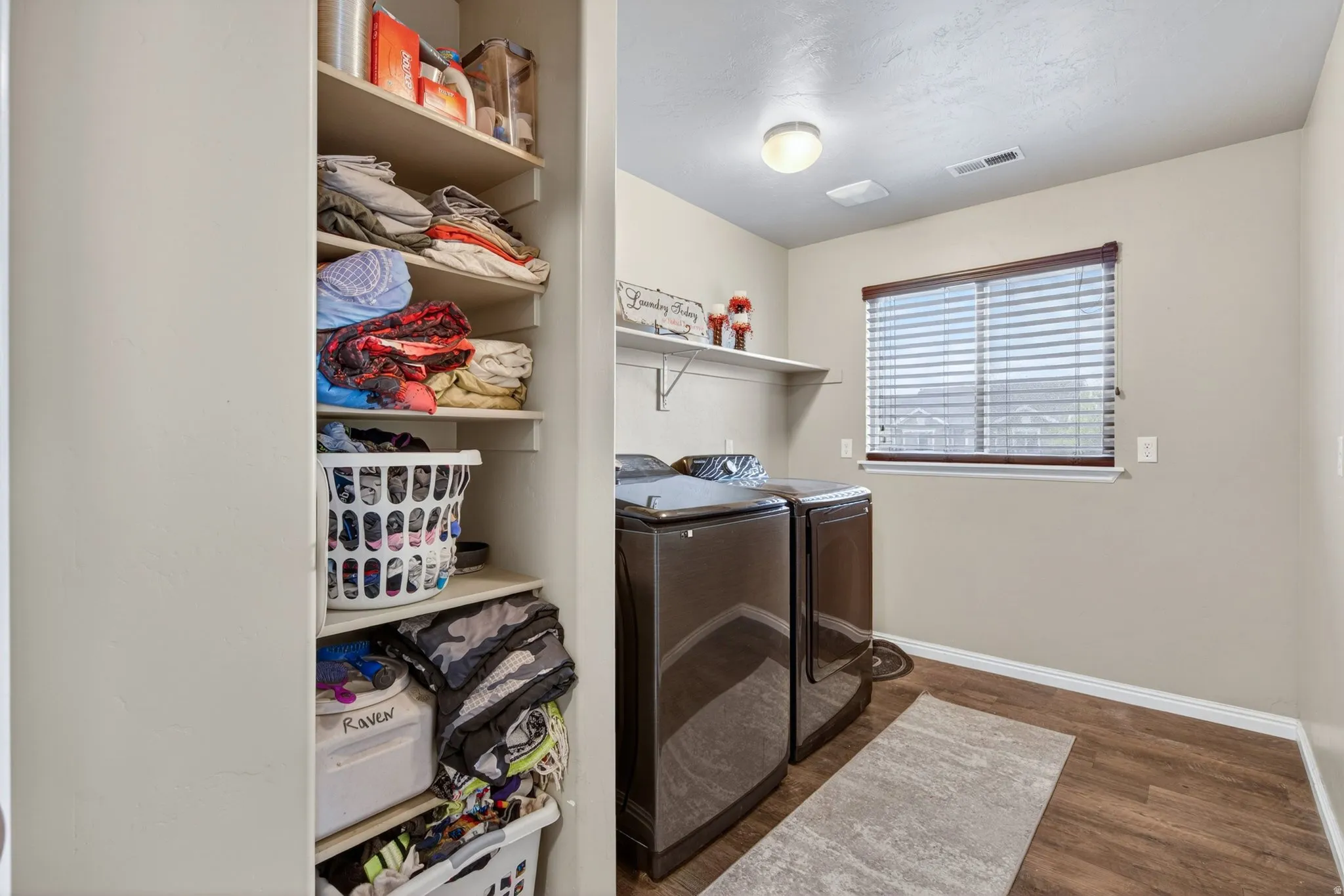 Laundry area featuring independent washer and dryer and dark wood-style flooring