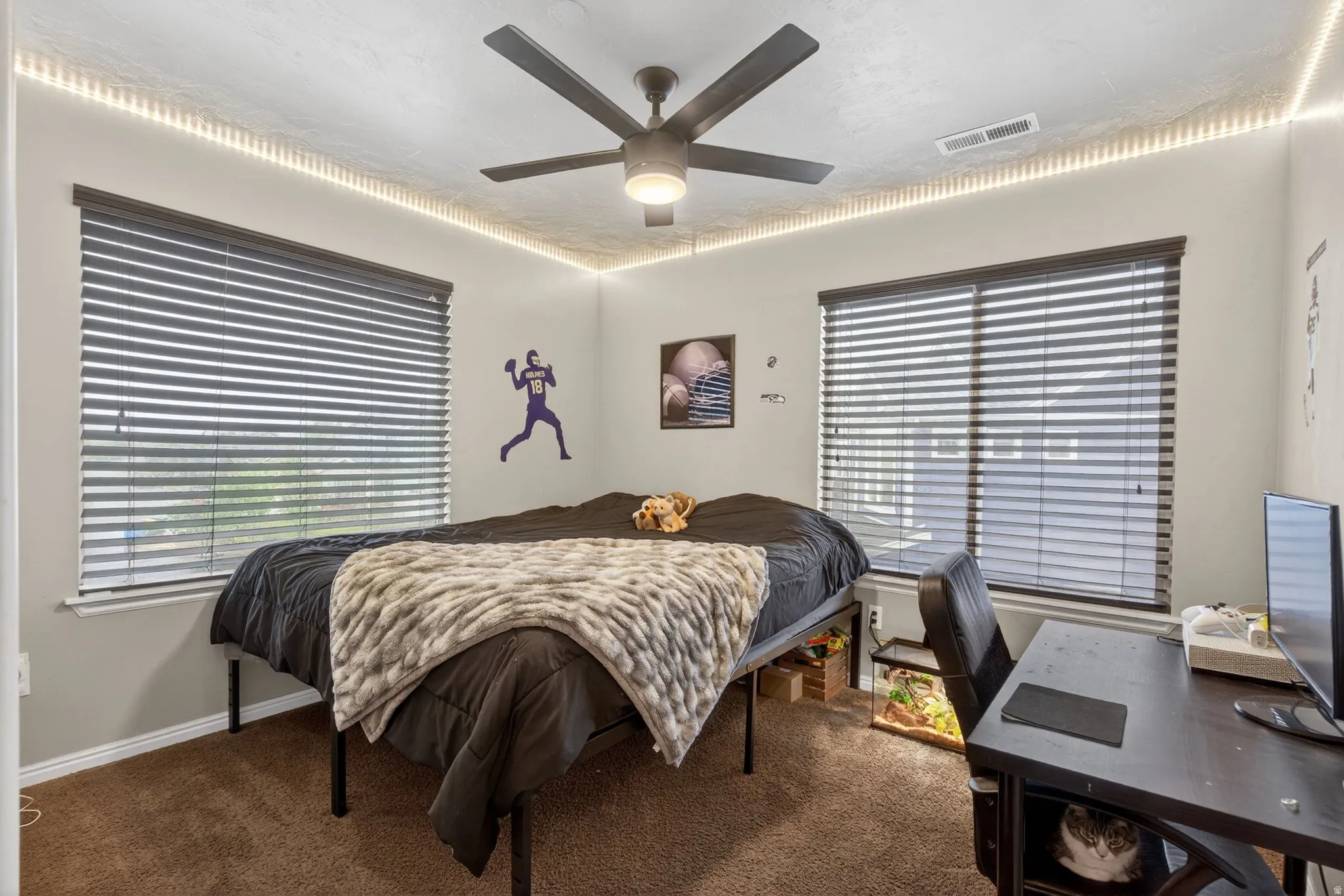 Carpeted bedroom featuring baseboards and ceiling fan