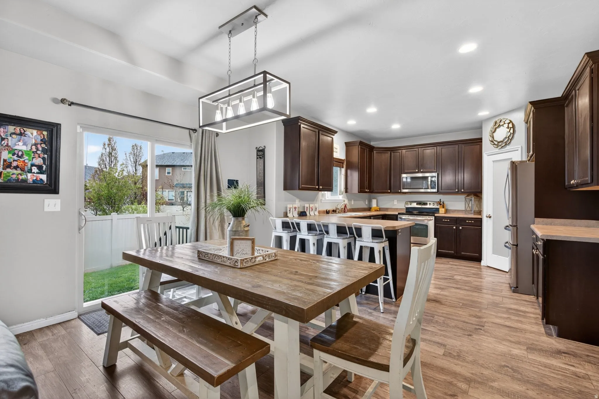 Dining area with light wood finished floors and recessed lighting