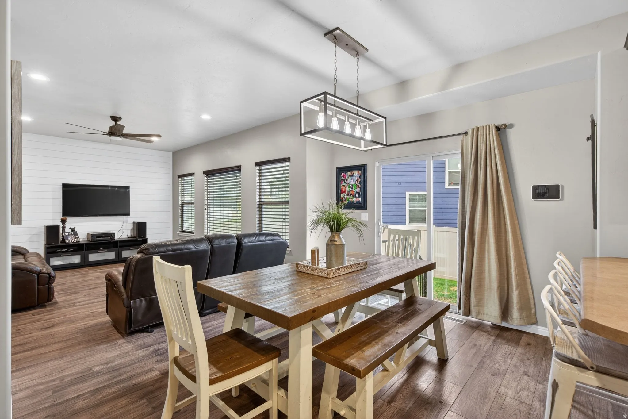 Dining area featuring dark wood finished floors, plenty of natural light, recessed lighting, a ceiling fan, and wood walls
