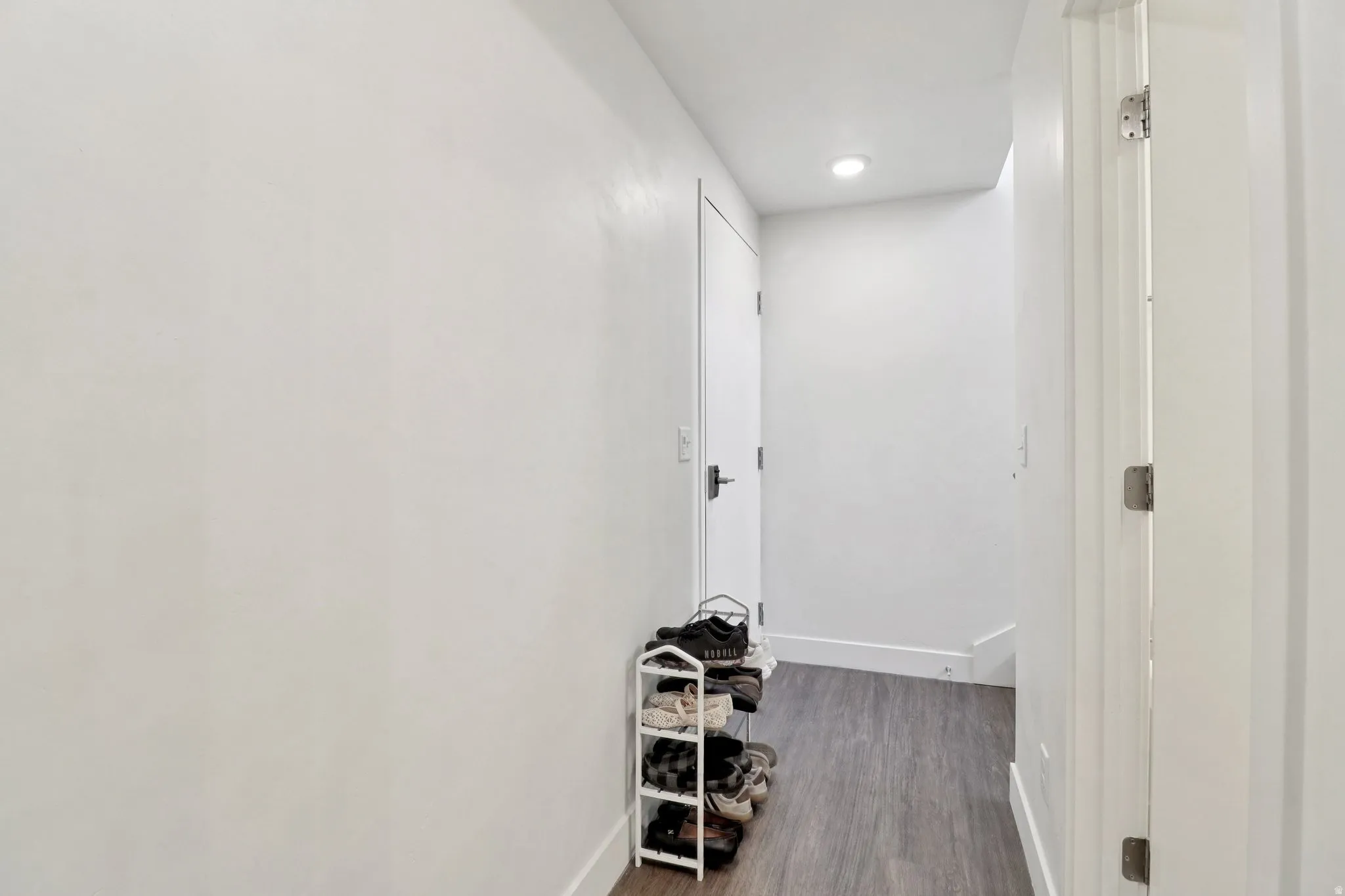 Hall with dark wood-style floors and recessed lighting