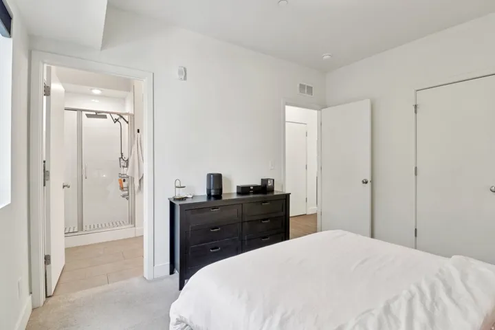 Bedroom with light carpet and a closet