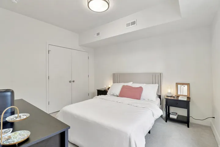 Bedroom featuring light colored carpet and a closet