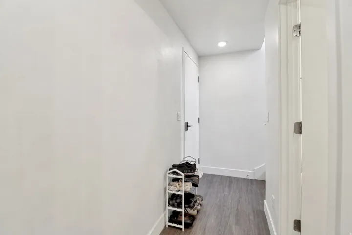 Hall with dark wood-style floors and recessed lighting